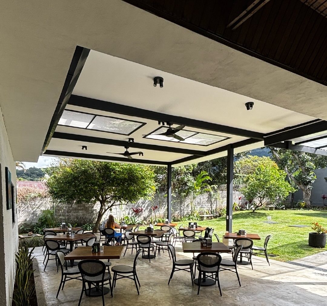 La terraza de Wö Kàpi con el pabellón abierto hacia el jardín y las montañas al fondo